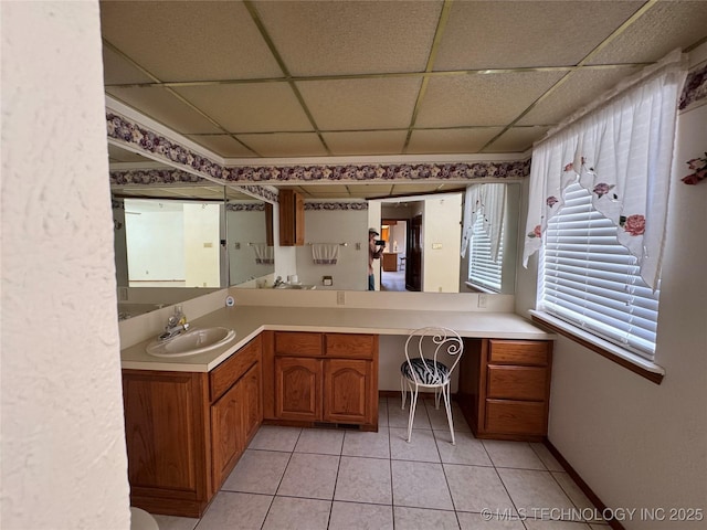 bathroom featuring a paneled ceiling, tile patterned flooring, vanity, and baseboards