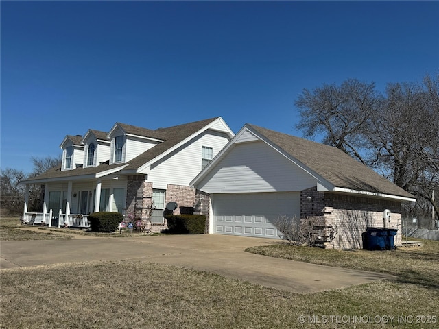 view of property exterior with a garage, covered porch, brick siding, and driveway