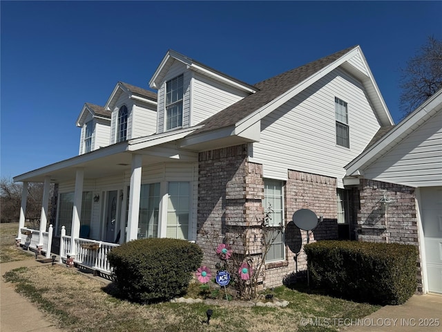 view of property exterior featuring a porch and brick siding