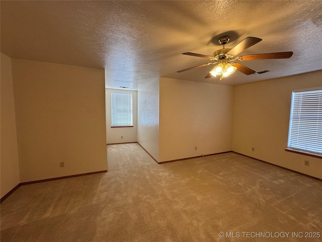 unfurnished room with visible vents, light carpet, ceiling fan, a textured ceiling, and baseboards