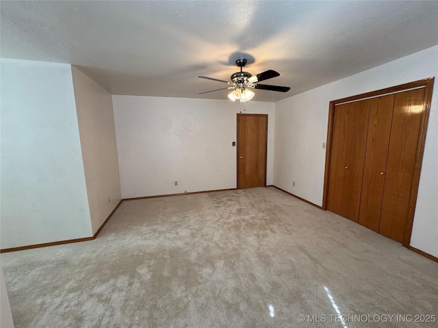 unfurnished bedroom featuring carpet, a ceiling fan, and baseboards