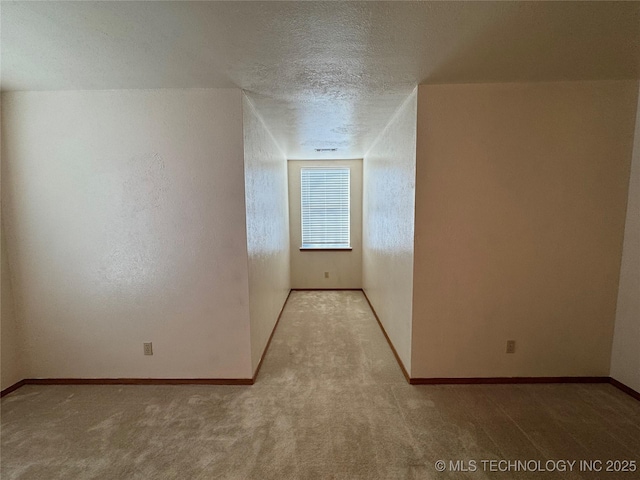 bonus room featuring a textured ceiling, carpet, and baseboards