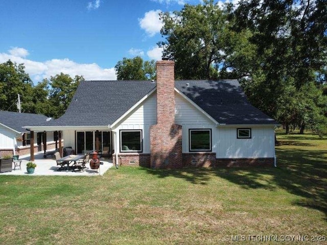 back of house with crawl space, a patio area, a chimney, and a lawn