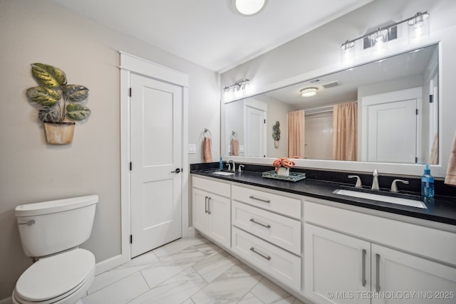 full bathroom with marble finish floor, a sink, toilet, and double vanity