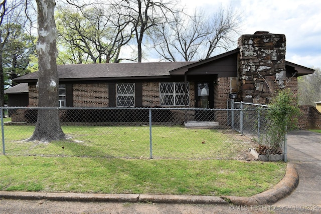 view of front of house with a fenced front yard, brick siding, and a front lawn