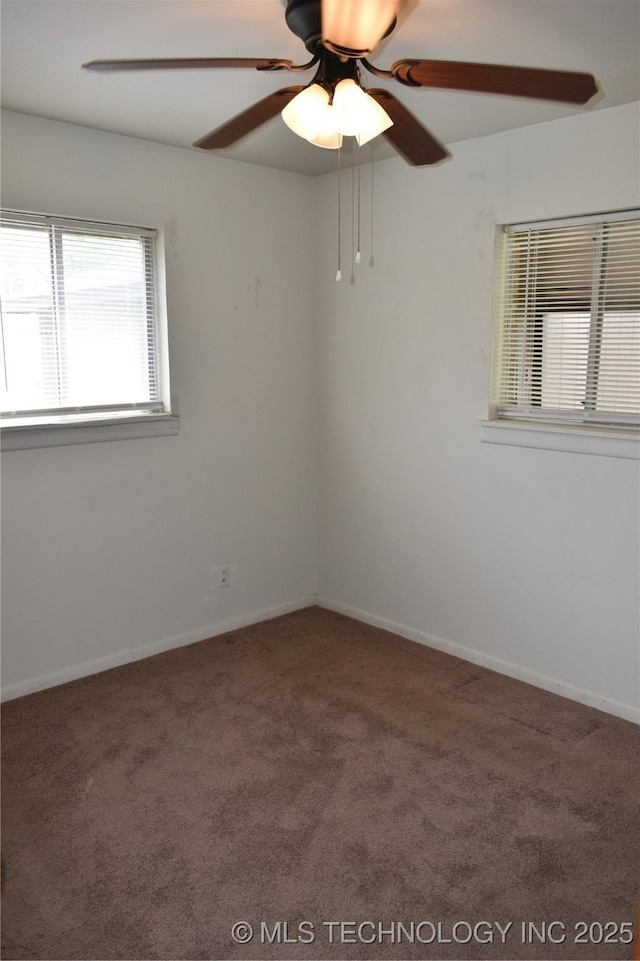 carpeted spare room featuring ceiling fan and baseboards