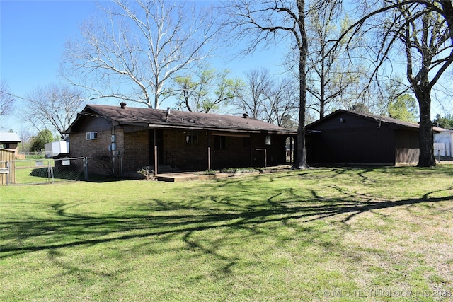 back of house featuring a yard, brick siding, and fence