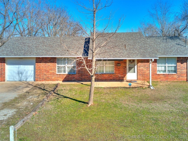 back of property featuring a yard, brick siding, an attached garage, and a shingled roof