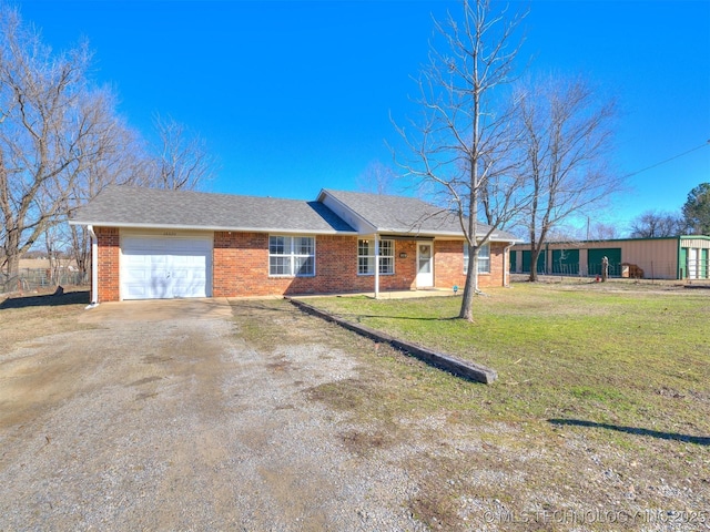 ranch-style home featuring a garage, dirt driveway, brick siding, and a front yard