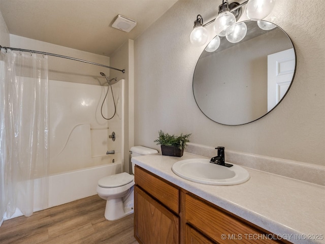 bathroom featuring visible vents, toilet, wood finished floors, shower / bath combination with curtain, and vanity