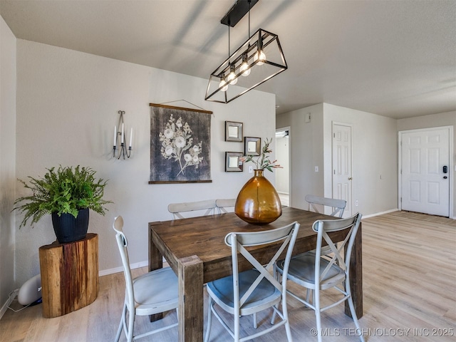 dining area with baseboards and light wood finished floors