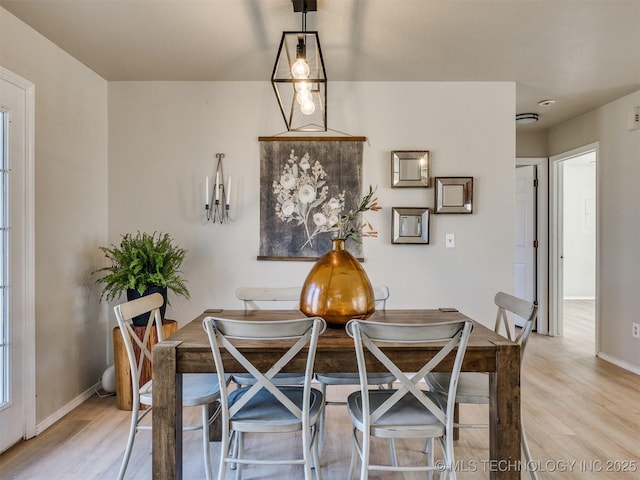 dining space with light wood-style flooring and baseboards