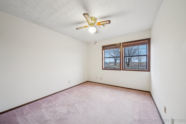 empty room featuring light carpet, baseboards, and a ceiling fan