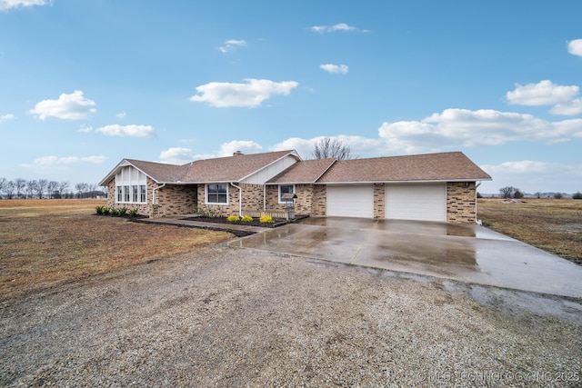 view of front of property featuring driveway, brick siding, roof with shingles, and an attached garage