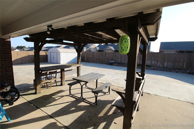 view of patio featuring an outbuilding, a fenced backyard, and a storage unit