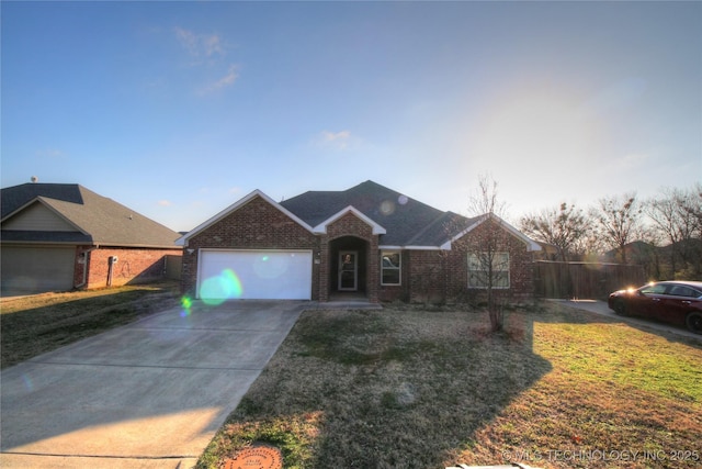 ranch-style home with brick siding, roof with shingles, a front yard, a garage, and driveway