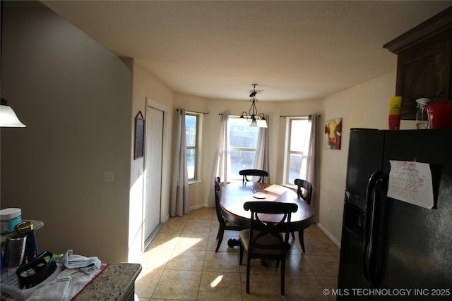 dining area with a chandelier, baseboards, and light tile patterned floors