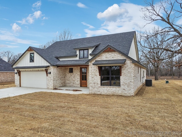 view of front of property with driveway, a shingled roof, an attached garage, a front yard, and brick siding