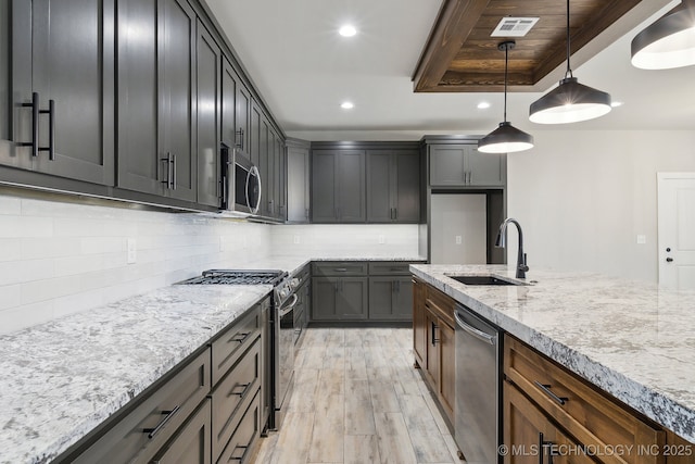 kitchen featuring light stone counters, recessed lighting, a sink, visible vents, and appliances with stainless steel finishes