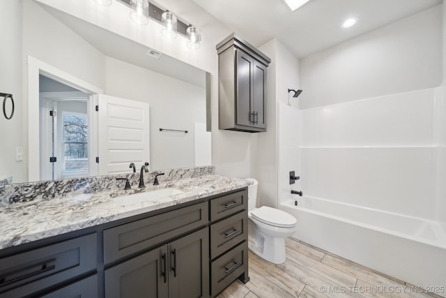 full bathroom featuring visible vents, toilet, shower / bathtub combination, wood tiled floor, and vanity