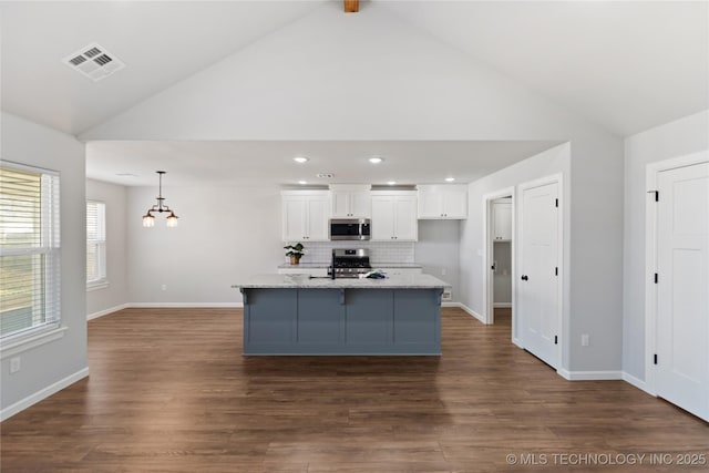 kitchen with visible vents, dark wood-type flooring, stainless steel appliances, white cabinetry, and backsplash