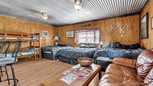 bedroom with light wood finished floors and a wall mounted air conditioner