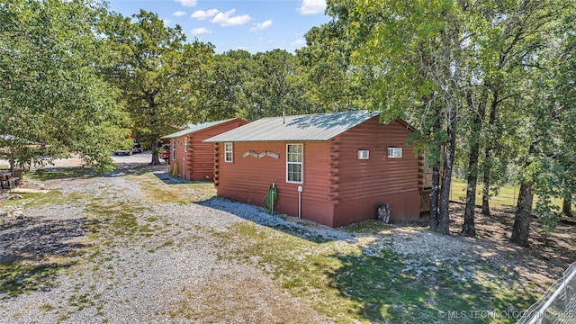 view of side of home featuring metal roof and log exterior