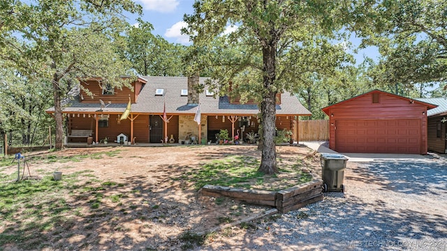 view of front of house with roof with shingles and an outbuilding