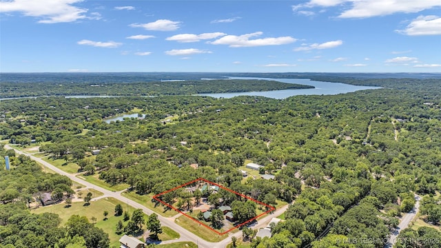 drone / aerial view featuring a water view and a wooded view