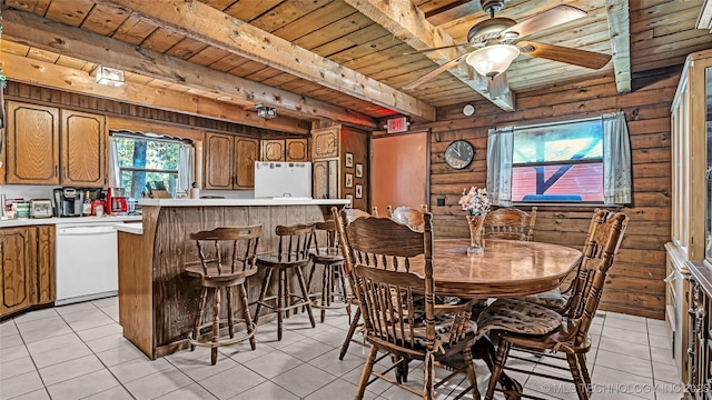 dining space featuring ceiling fan, wood ceiling, beamed ceiling, and light tile patterned floors