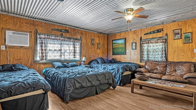 bedroom featuring an AC wall unit and wood finished floors