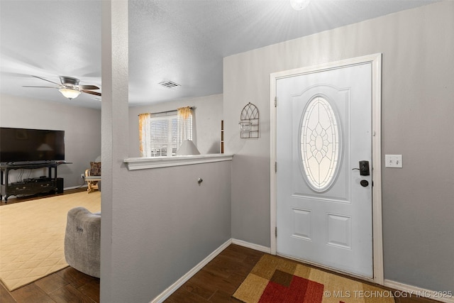 entryway with visible vents, ceiling fan, baseboards, and wood finished floors