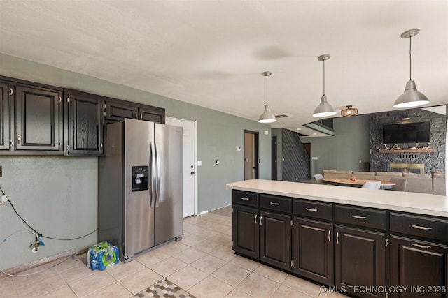 kitchen featuring light countertops, dark cabinetry, stainless steel refrigerator with ice dispenser, and decorative light fixtures