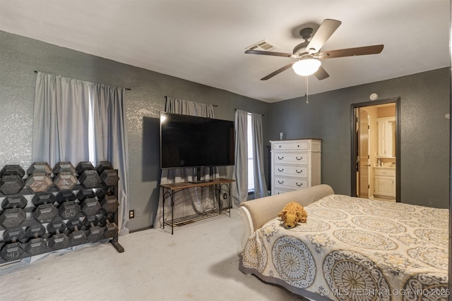 bedroom featuring carpet floors, a textured wall, visible vents, and ceiling fan
