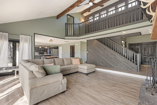living room with high vaulted ceiling, a ceiling fan, stairs, and wood finished floors