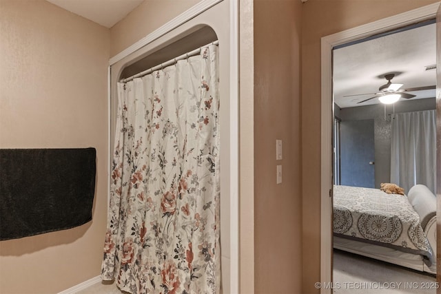 full bath featuring ensuite bathroom, a ceiling fan, baseboards, and a shower with shower curtain