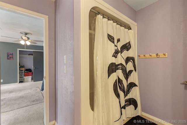 bathroom featuring baseboards, ceiling fan, and a shower with curtain