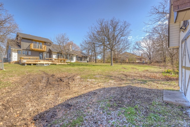view of yard featuring a balcony and a deck