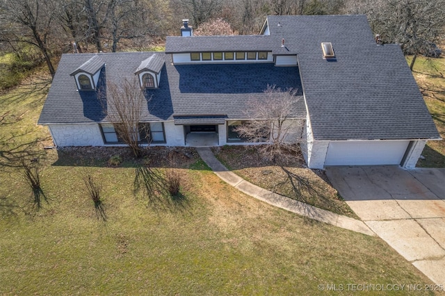 exterior space with roof with shingles, driveway, a chimney, and a front yard