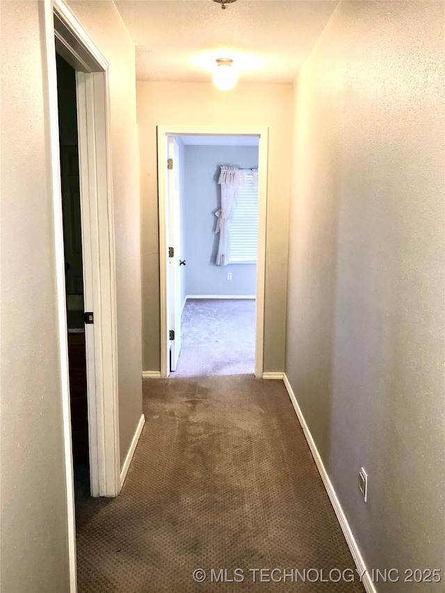 hall with carpet floors and baseboards