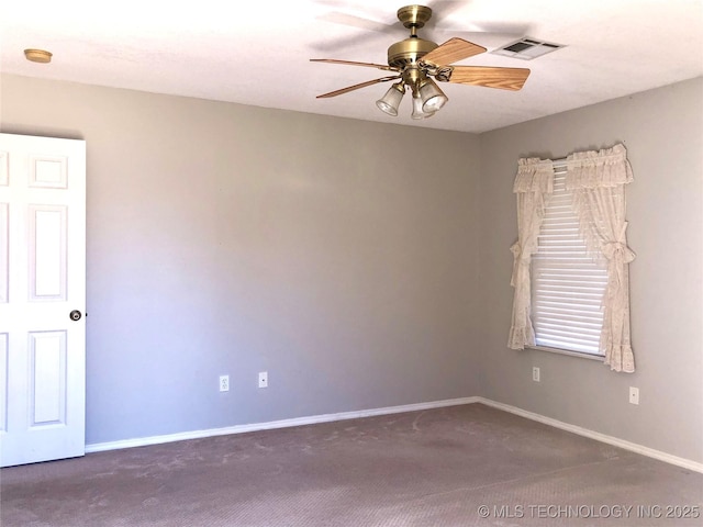 carpeted empty room with baseboards, visible vents, and a ceiling fan