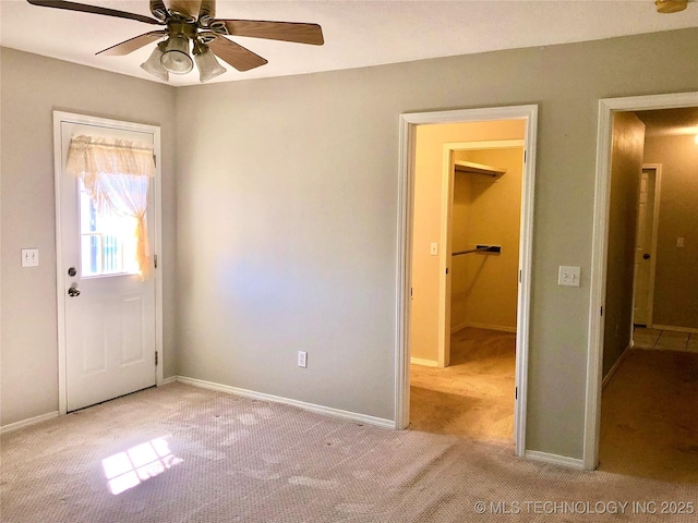 interior space with carpet floors, baseboards, and a ceiling fan