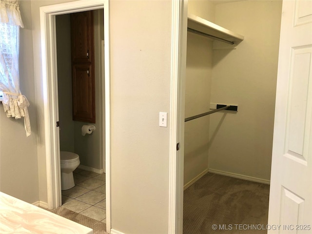 bathroom with toilet, tile patterned flooring, and baseboards