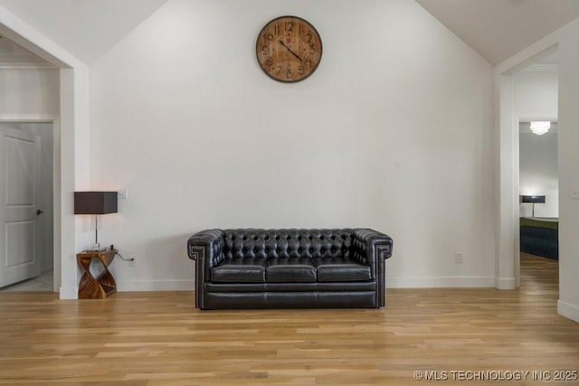 sitting room with lofted ceiling, baseboards, and wood finished floors