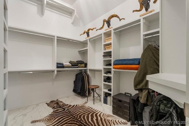 walk in closet featuring marble finish floor