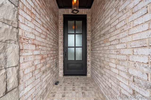 property entrance featuring brick siding