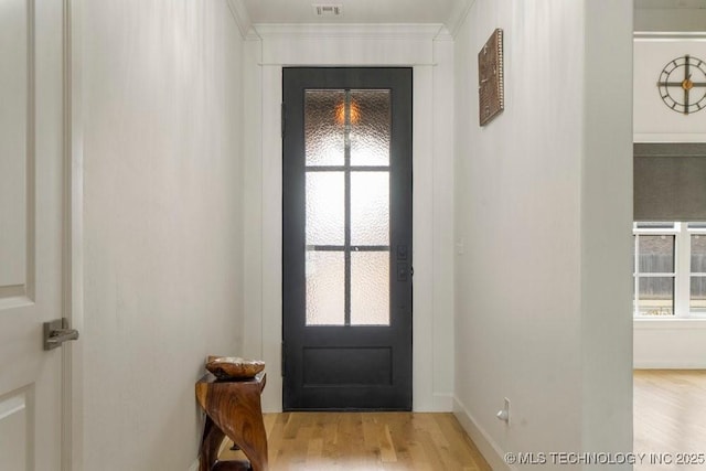 entryway featuring plenty of natural light, wood finished floors, and crown molding