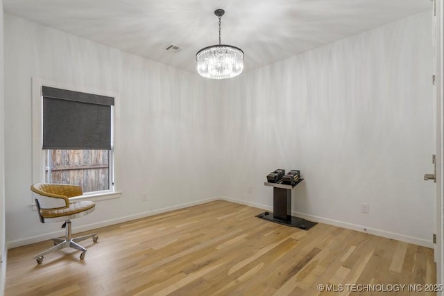 unfurnished room featuring an inviting chandelier, light wood-type flooring, visible vents, and baseboards