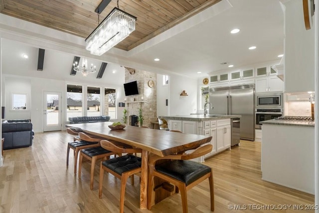 dining area with a large fireplace, wood ceiling, an inviting chandelier, light wood-style floors, and recessed lighting