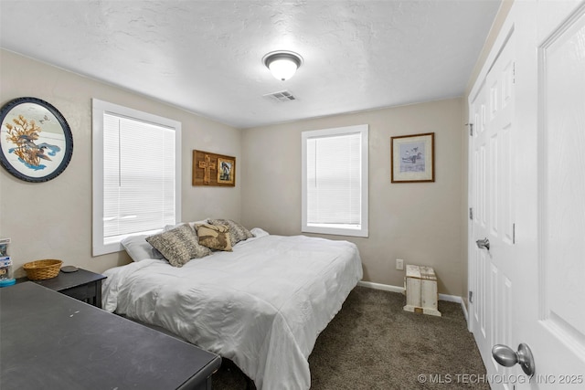 bedroom with dark colored carpet, multiple windows, visible vents, and baseboards